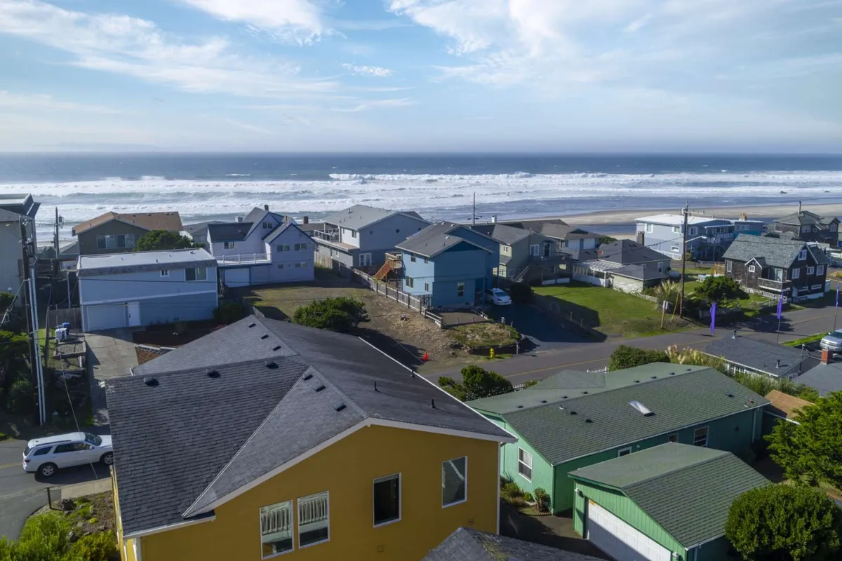 This exterior image captures a sweeping ocean view framed by colorful coastal houses, evoking the relaxed atmosphere of Lincoln City and its community-centric vibe. The scene hints at local gatherings and the easy access to beautiful beaches, inviting exploration and social activities.
